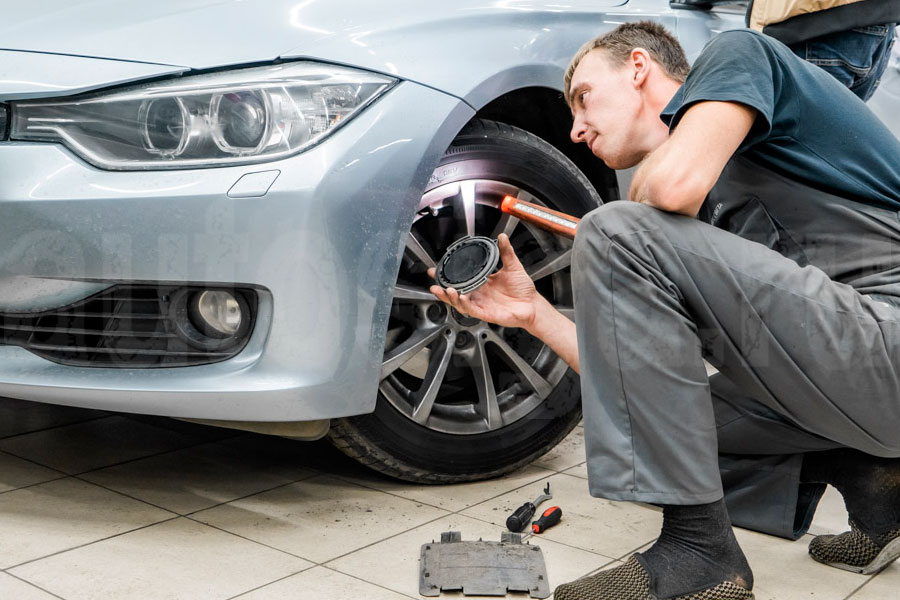 Автоподборщик с диагностическим сканером проводит компьютерную проверку автомобиля в сервисе