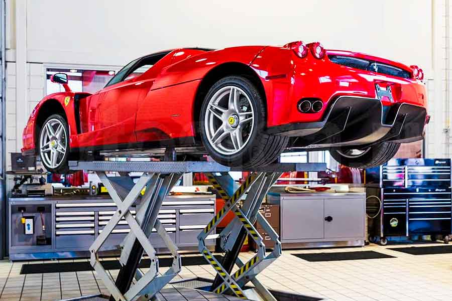 Машина на подъёмнике в СТО – диагностика перед покупкой подержанного авто Автомобиль на подъёмнике в автосервисе во время технической проверки перед покупкой