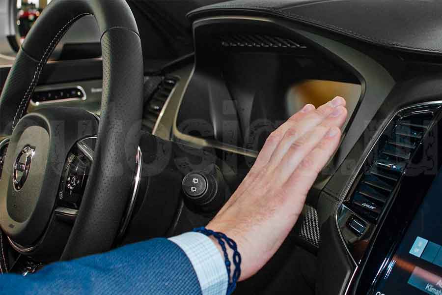 Осмотр панели приборов и электроники автомобиля при выборе подержанной машины Человек проверяет панель приборов в салоне автомобиля перед покупкой