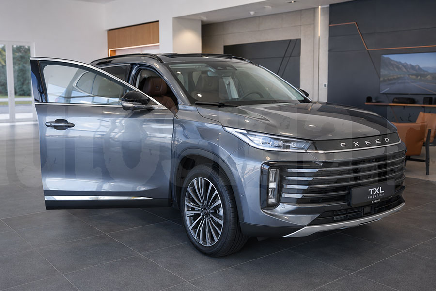 EXEED TXL Prestige 2024 в автосалоне с фирменным логотипом на решётке
